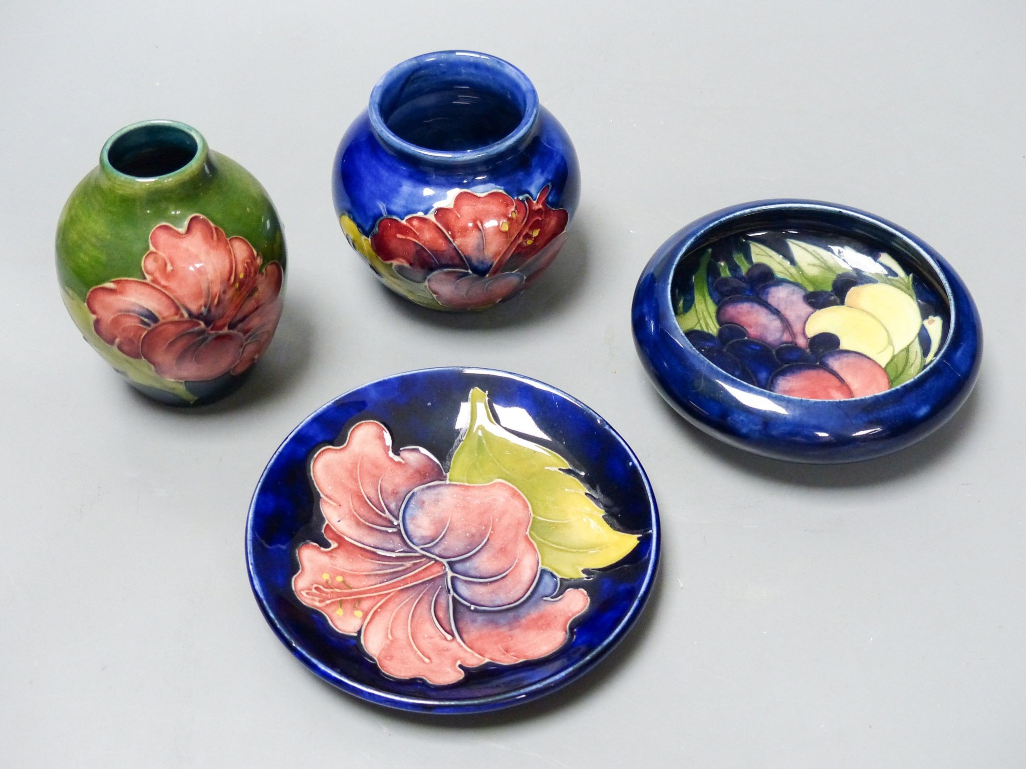 Two Moorcroft Hibiscus pattern vases and a similar dish together with a Moorcroft wisteria pattern dish, 11cm